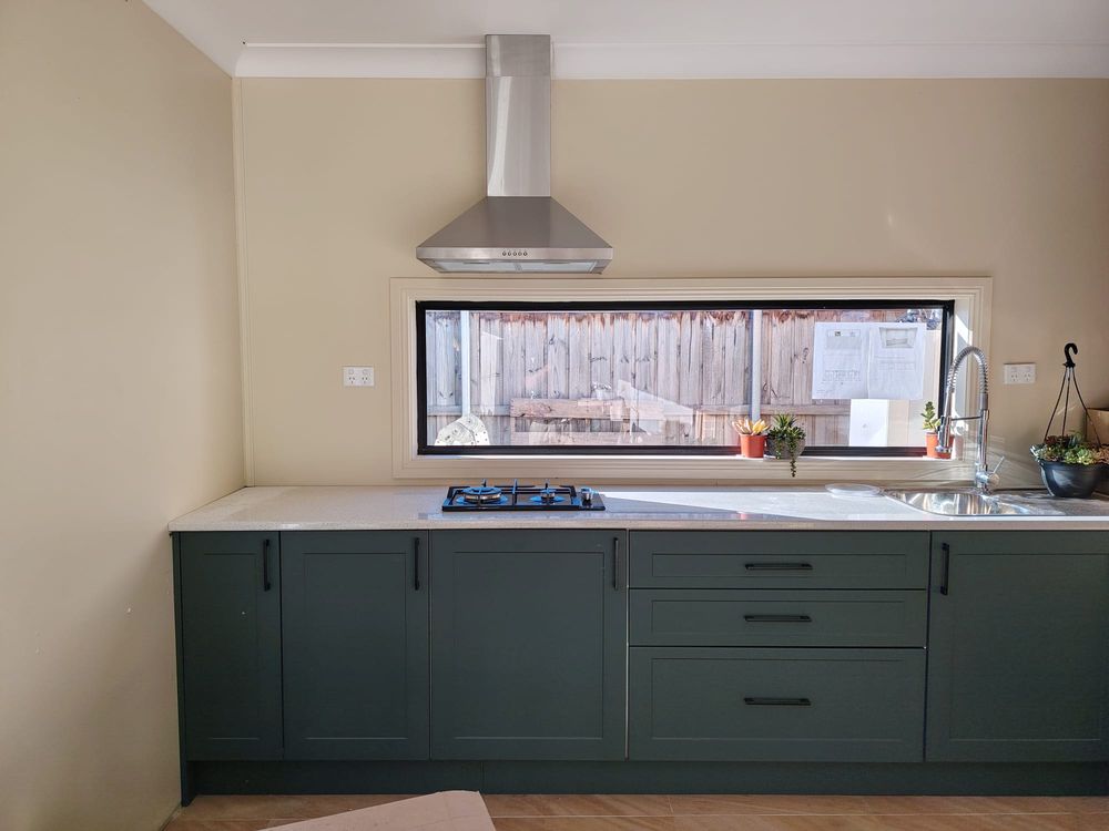 New kitchen with range hood and cooktop wired by George & Son's