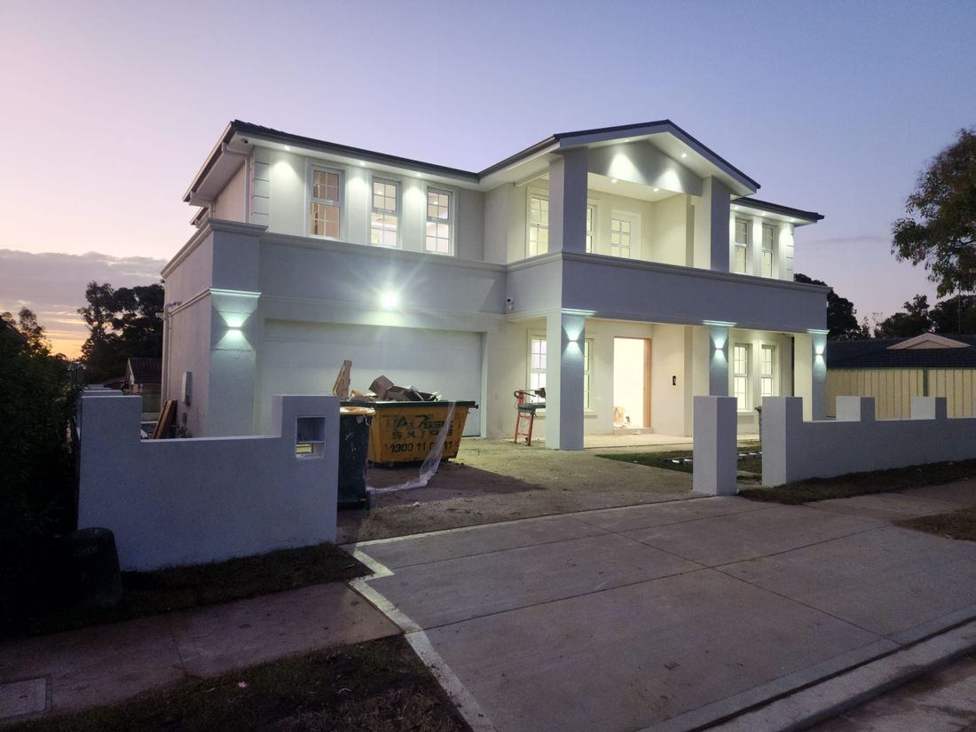 Exterior facade lighting on a new two-storey home at dusk